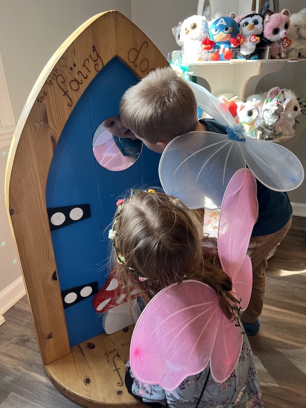 Boy and girl looking through fairy door